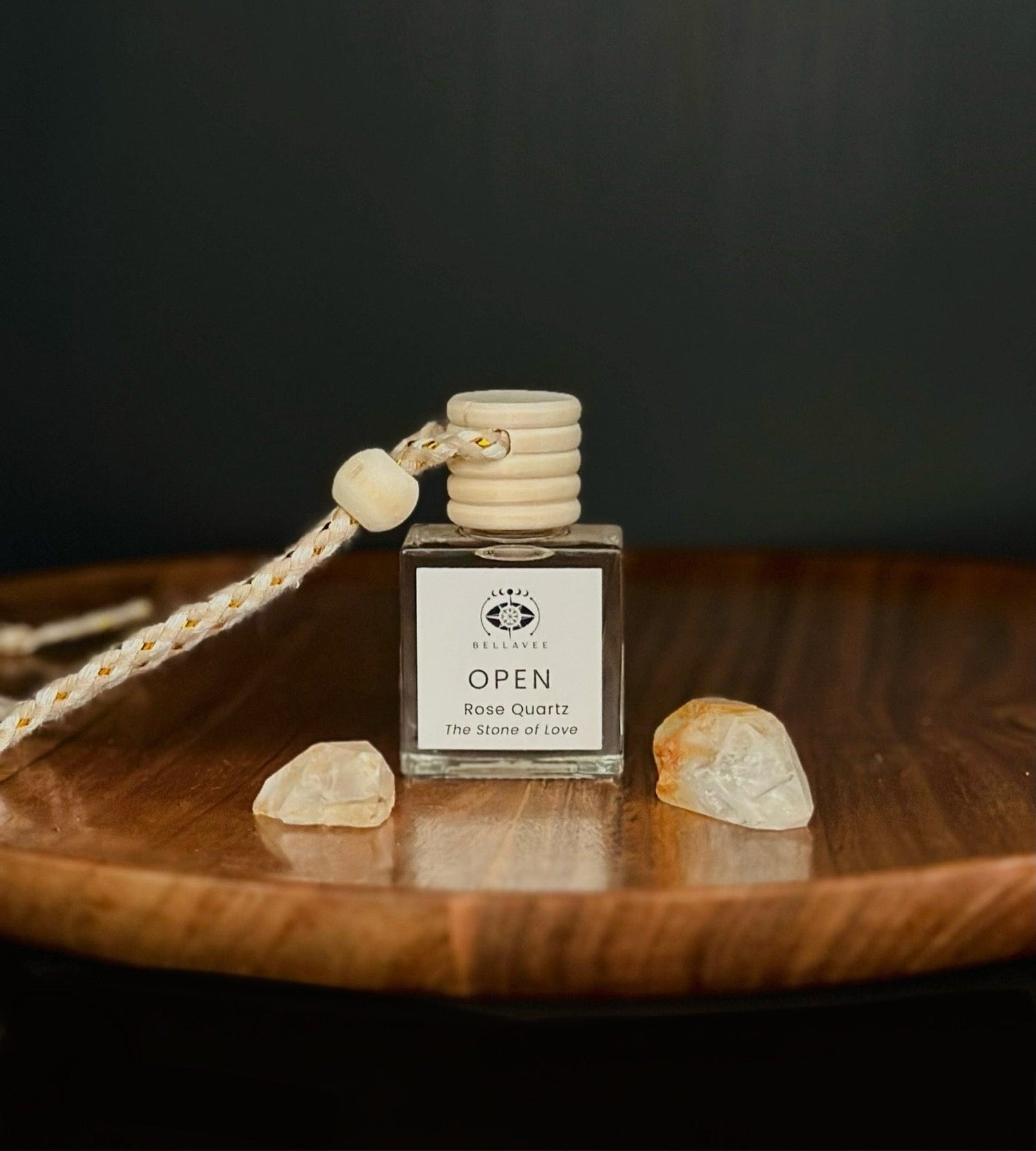 Crystal-infused diffuser labeled “Open” with Rose Quartz stones on a wooden surface.