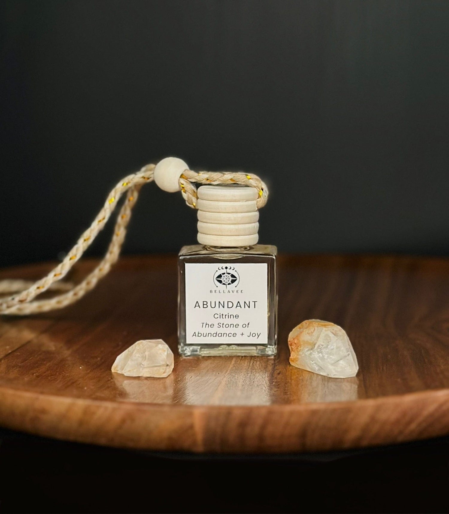 Crystal-infused diffuser labeled “Abundant” with Citrine stones on a wooden surface.