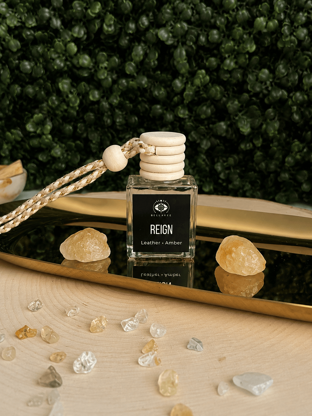 BellaVee REIGN crystal car diffuser with leather and amber fragrance displayed on a gold tray with citrine crystals. Handcrafted non-toxic car diffuser for grounding, luxury home fragrance, and intentional living.