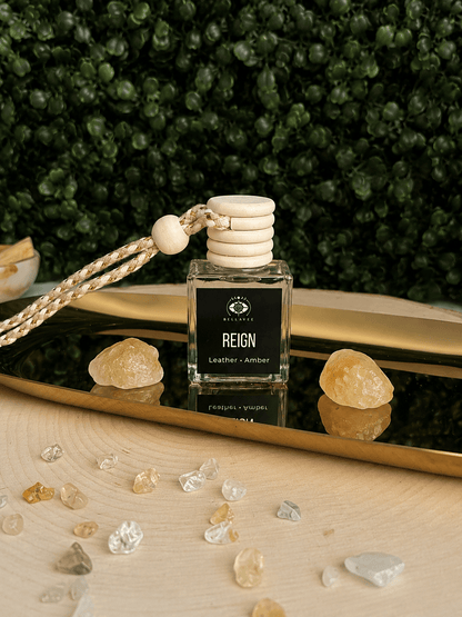 BellaVee REIGN crystal car diffuser with leather and amber fragrance displayed on a gold tray with citrine crystals. Handcrafted non-toxic car diffuser for grounding, luxury home fragrance, and intentional living.