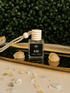 BellaVee REIGN crystal car diffuser with leather and amber fragrance displayed on a gold tray with citrine crystals. Handcrafted non-toxic car diffuser for grounding, luxury home fragrance, and intentional living.
