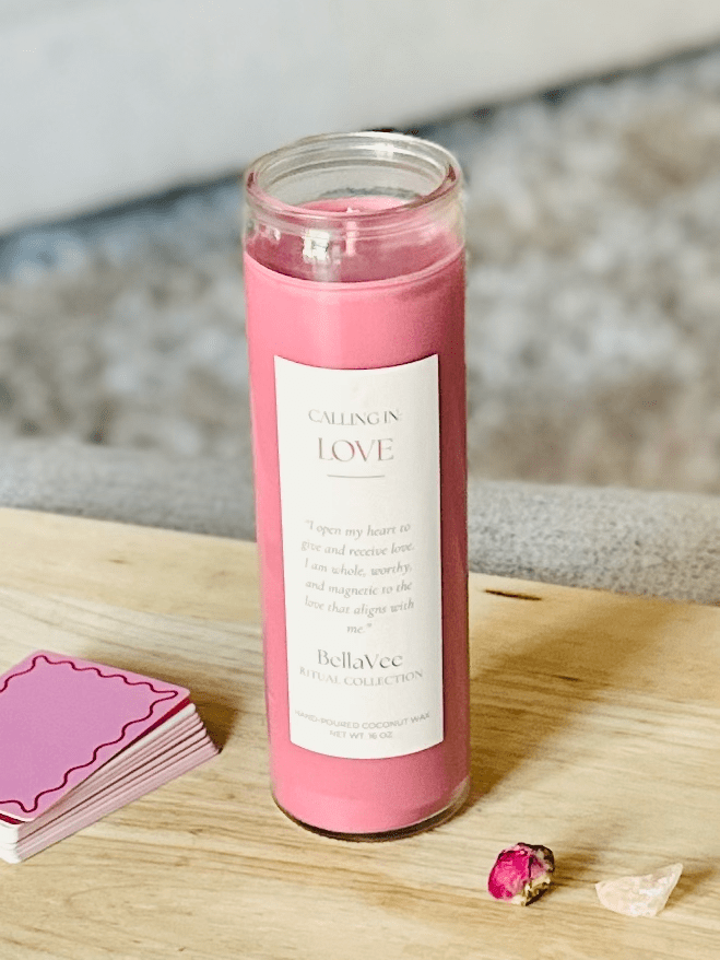  Love Ritual Candle beside dried rose and crystal, with cozy neutral couch in background