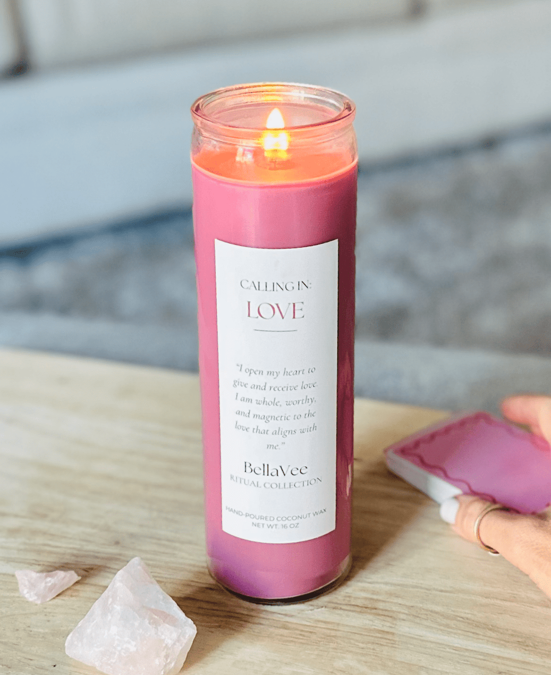 Lit Love Ritual Candle casting a soft pink glow in a warm, inviting setting