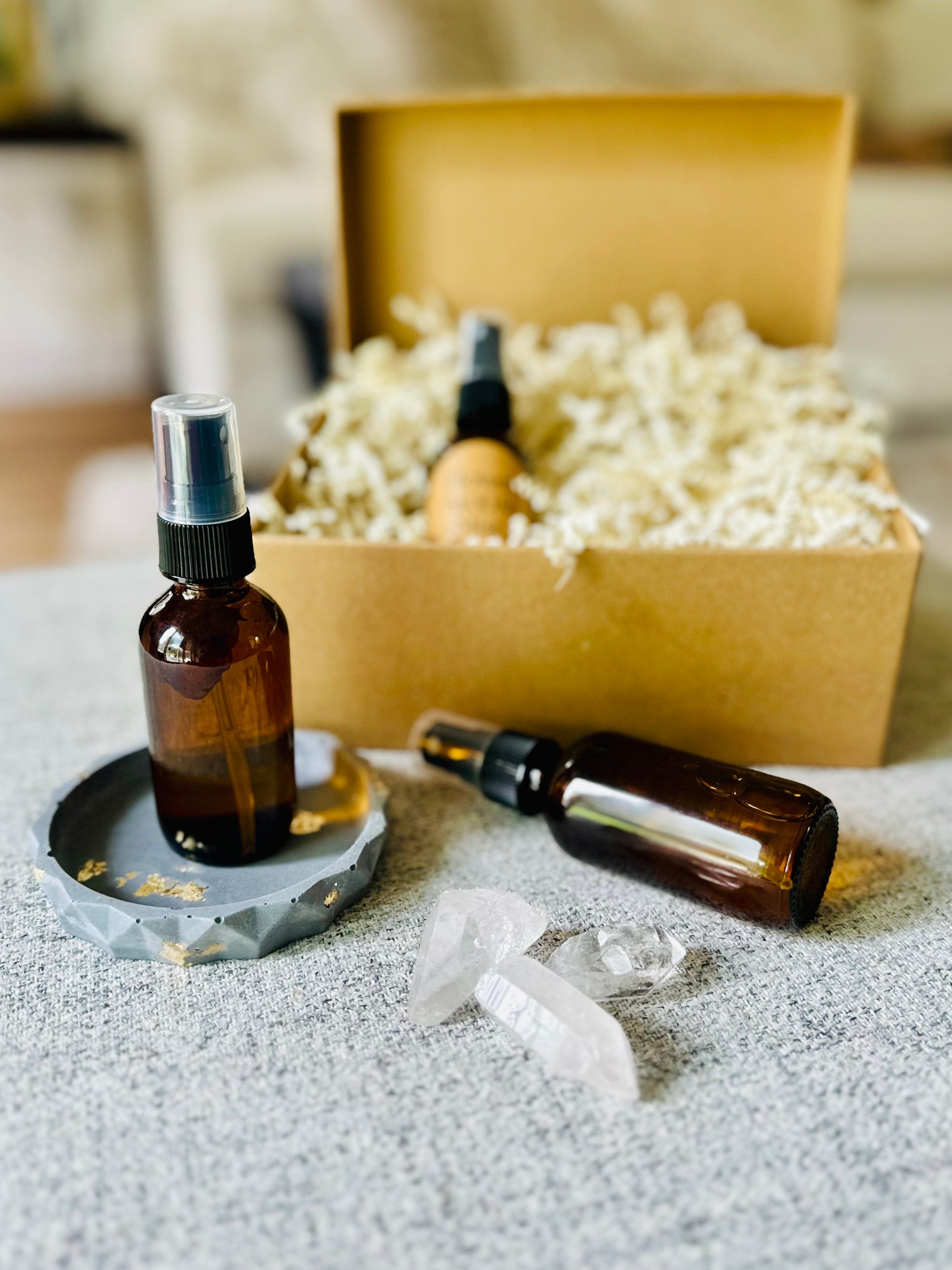 Multiple bottles of Flower Moon Mist bottle mid-spray against a sunlit background