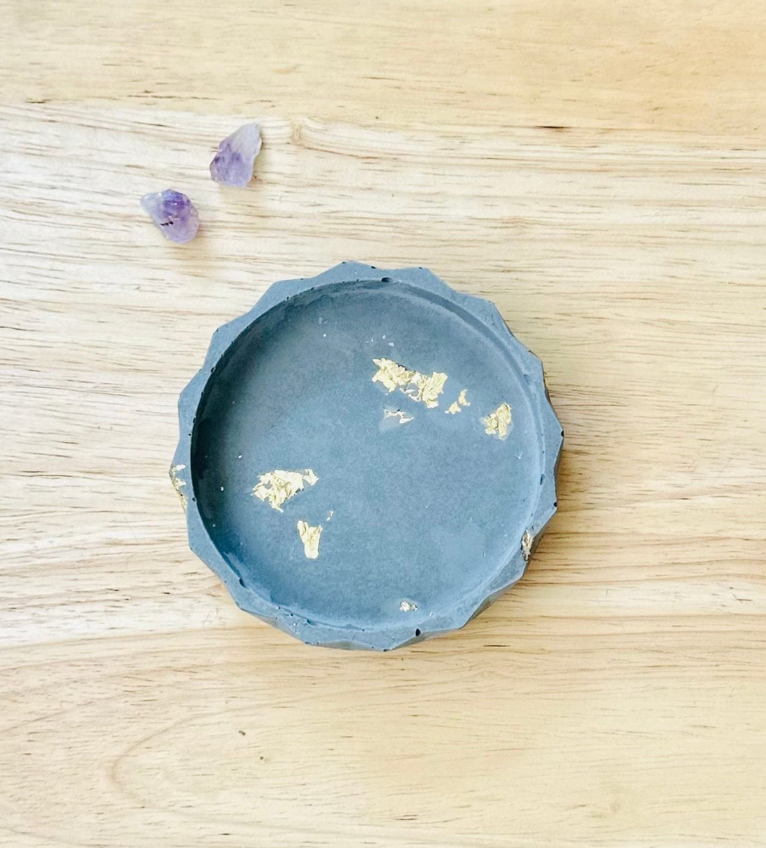 Handmade cement dish with gold flecks on neutral background