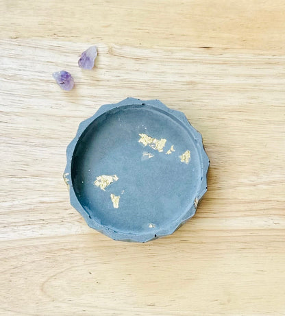 Handmade cement dish with gold flecks on neutral background