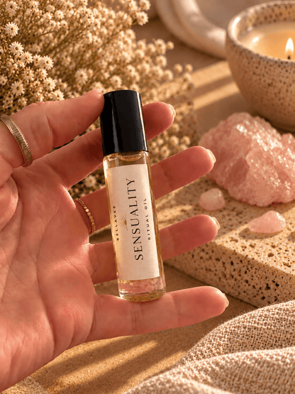 Close-up of a woman holding BellaVee SENSUALITY Ritual Oil roll-on with rose quartz chips against a warm, neutral background with soft natural lighting.