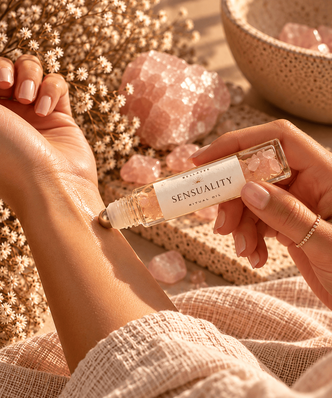 Woman applying BellaVee SENSUALITY Ritual Oil infused with rose quartz chips to her wrist during an intimate self-care ritual.