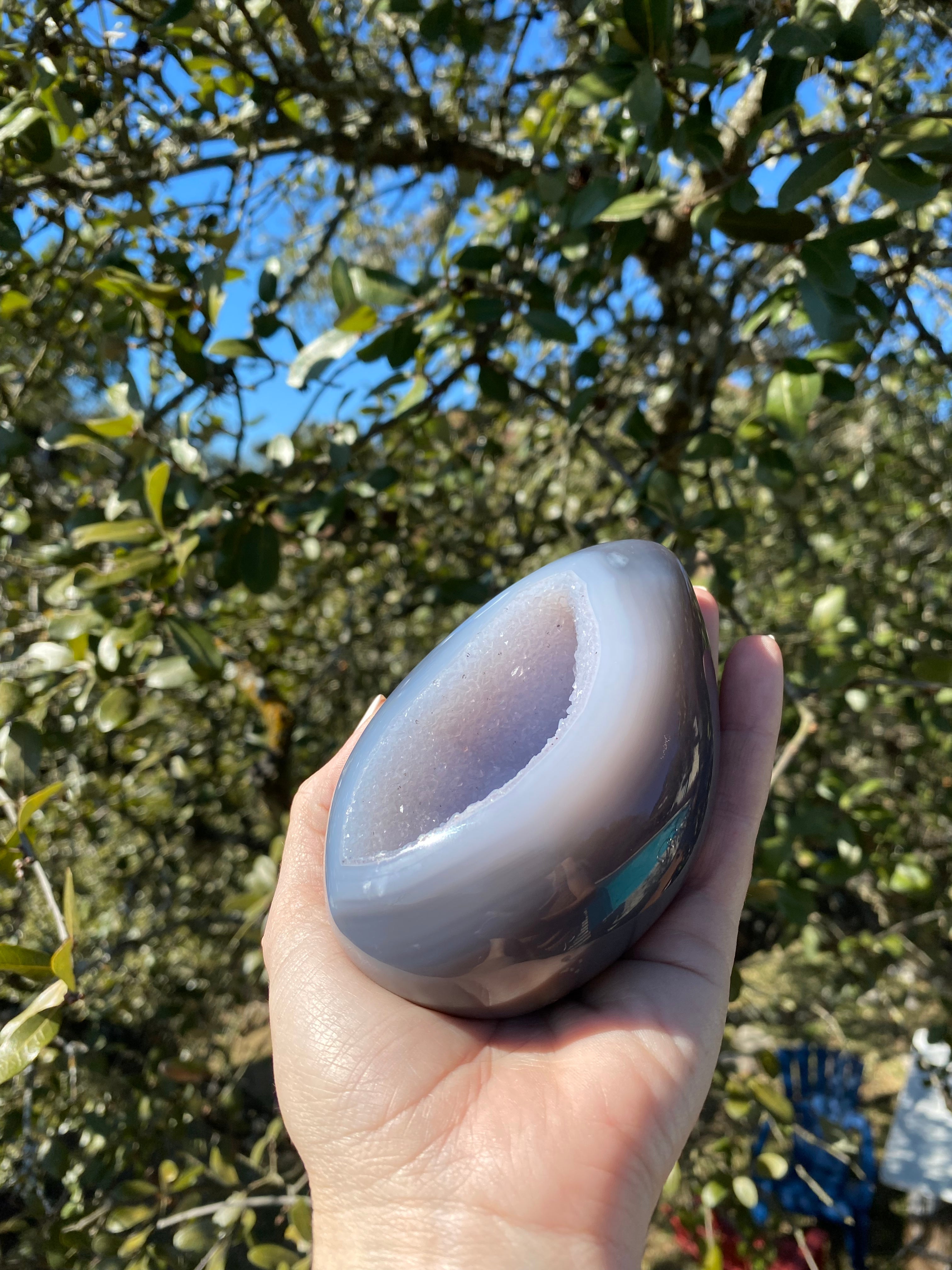 Egg-shaped Amethyst Geode with polished blue Agate exterior and lavender crystals, perfect for decor or collections