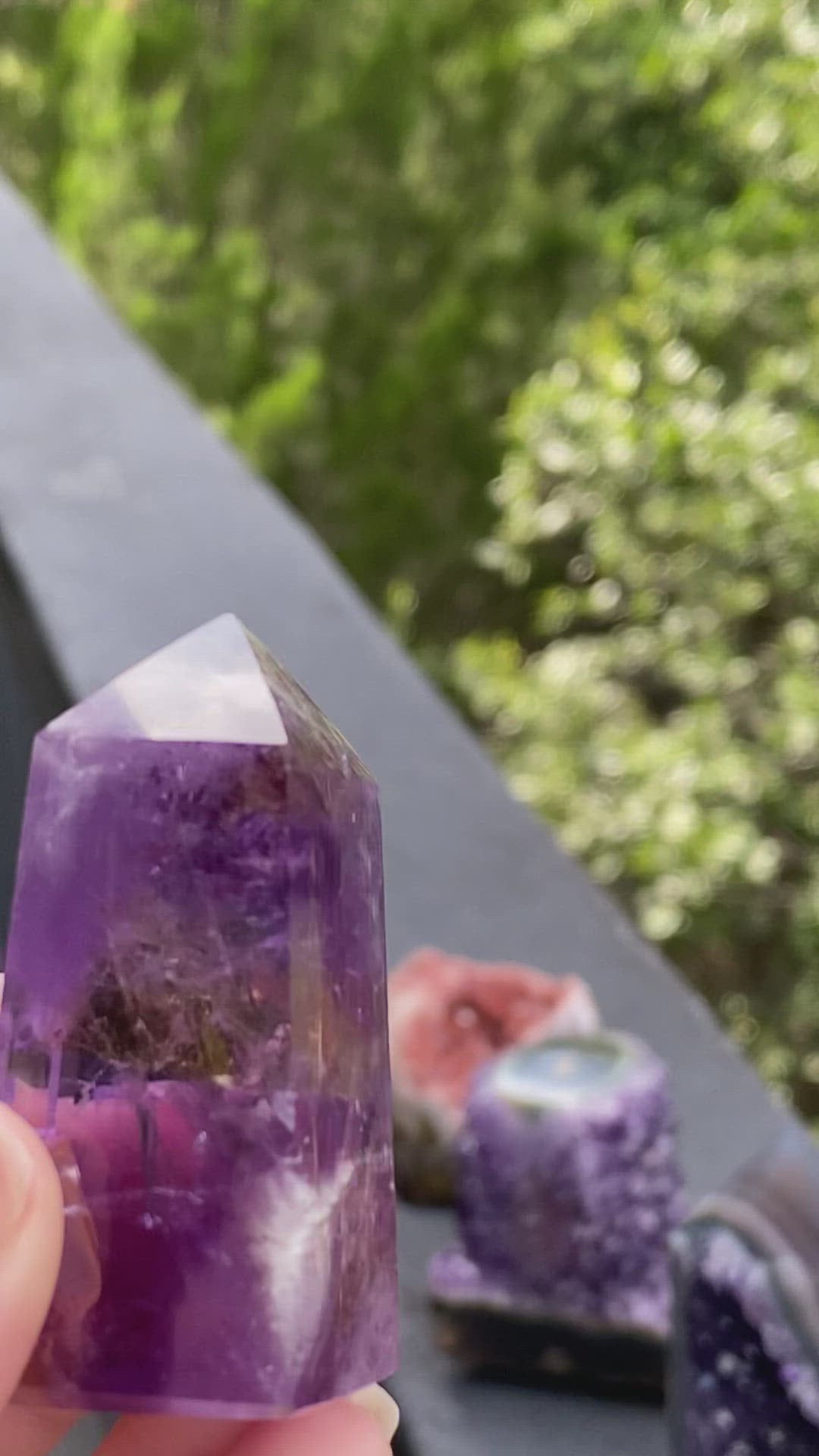 Translucent Amethyst crystal tower glowing in the sunlight, radiating spiritual healing and calm energy.