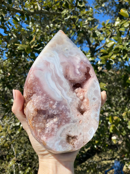 Held under the sun, the Rose Amethyst Tear Drop displays its dazzling geode cavity, filled with lavender crystals over rose jasper