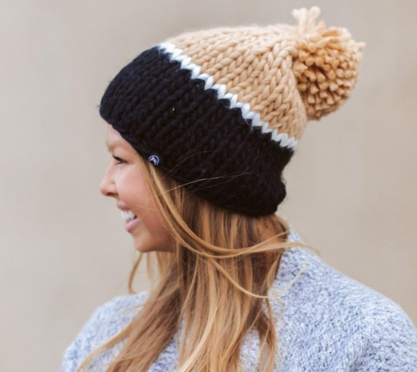 Carly Cozy Beanie with soft chunky knit fabric, faux fur pom-pom, and slouchy design, ideal for colder weather