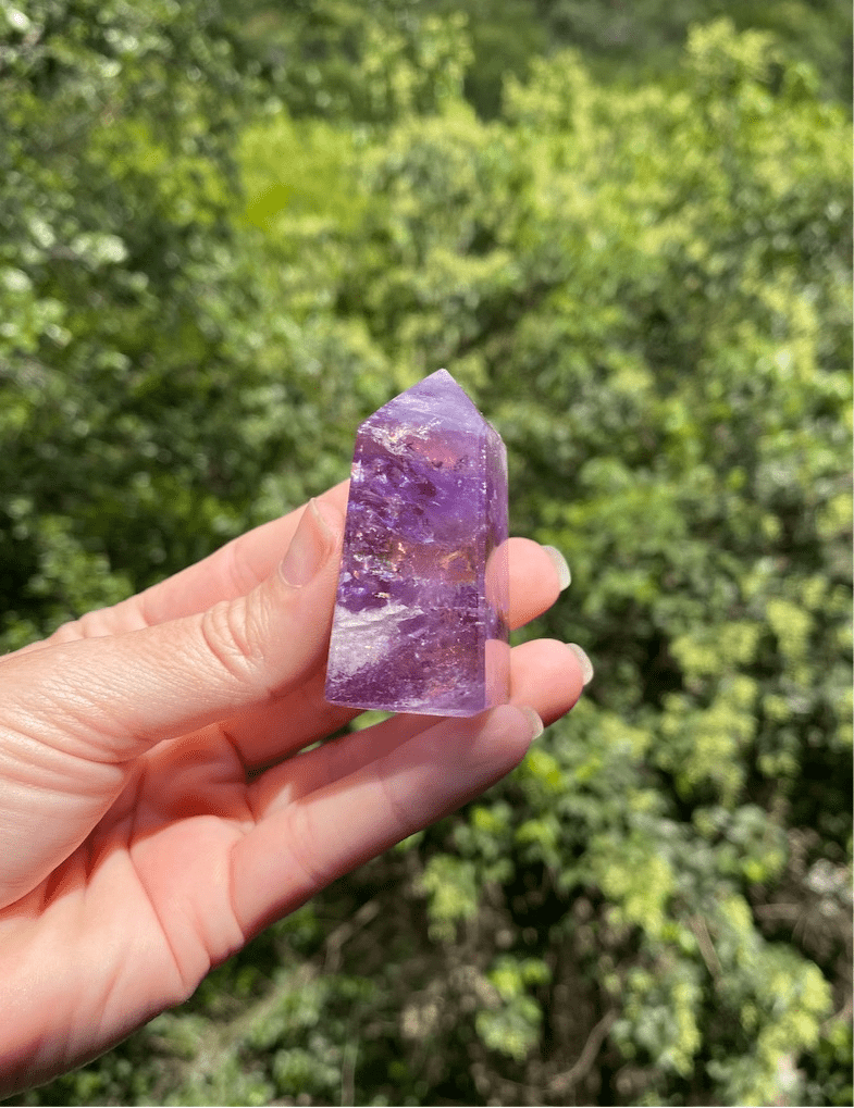 Polished Brazilian Amethyst crystal tower with translucent lavender and purple hues, promoting calmness and spiritual healing.