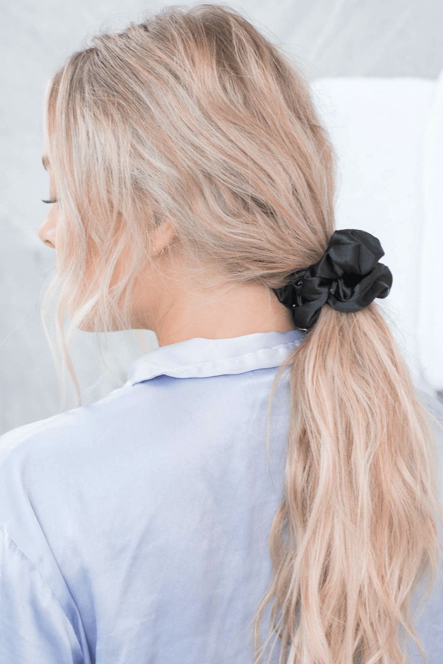 Black satin scrunchie from the Bliss set, casually holding a ponytail for a sleek and simple look.
