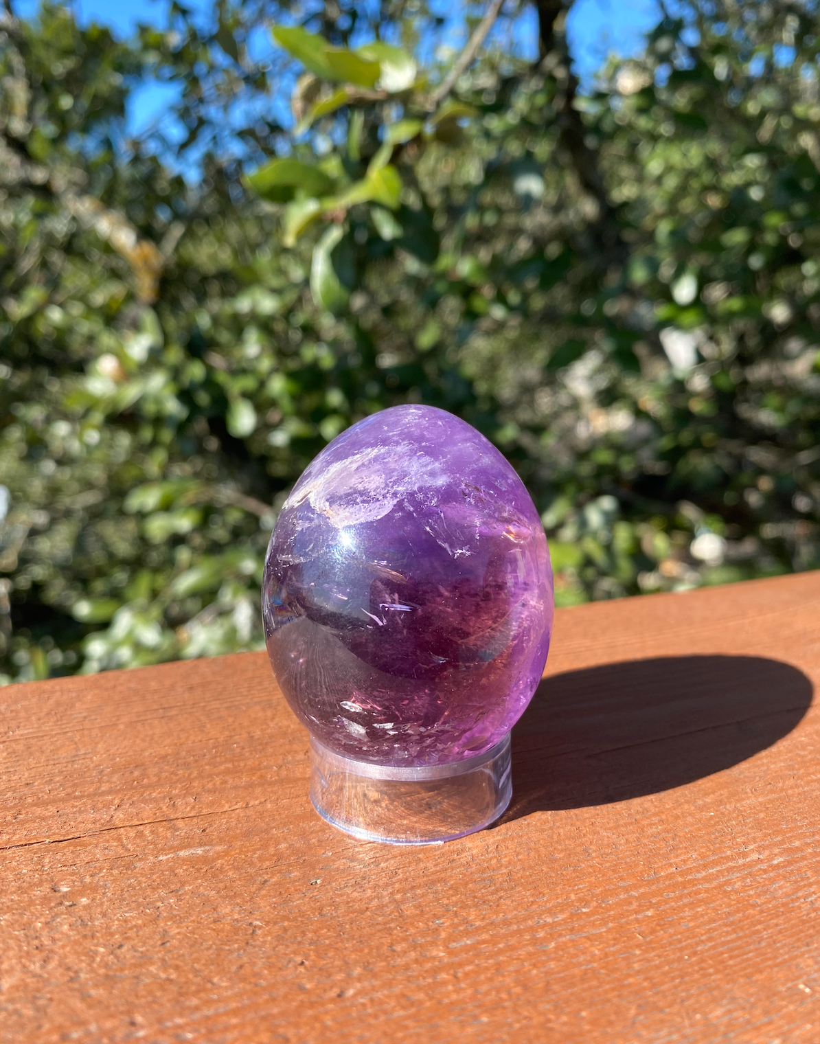 Brazilian Amethyst egg sparkling in the sunlight, showcasing its vibrant purple color and spiritual properties