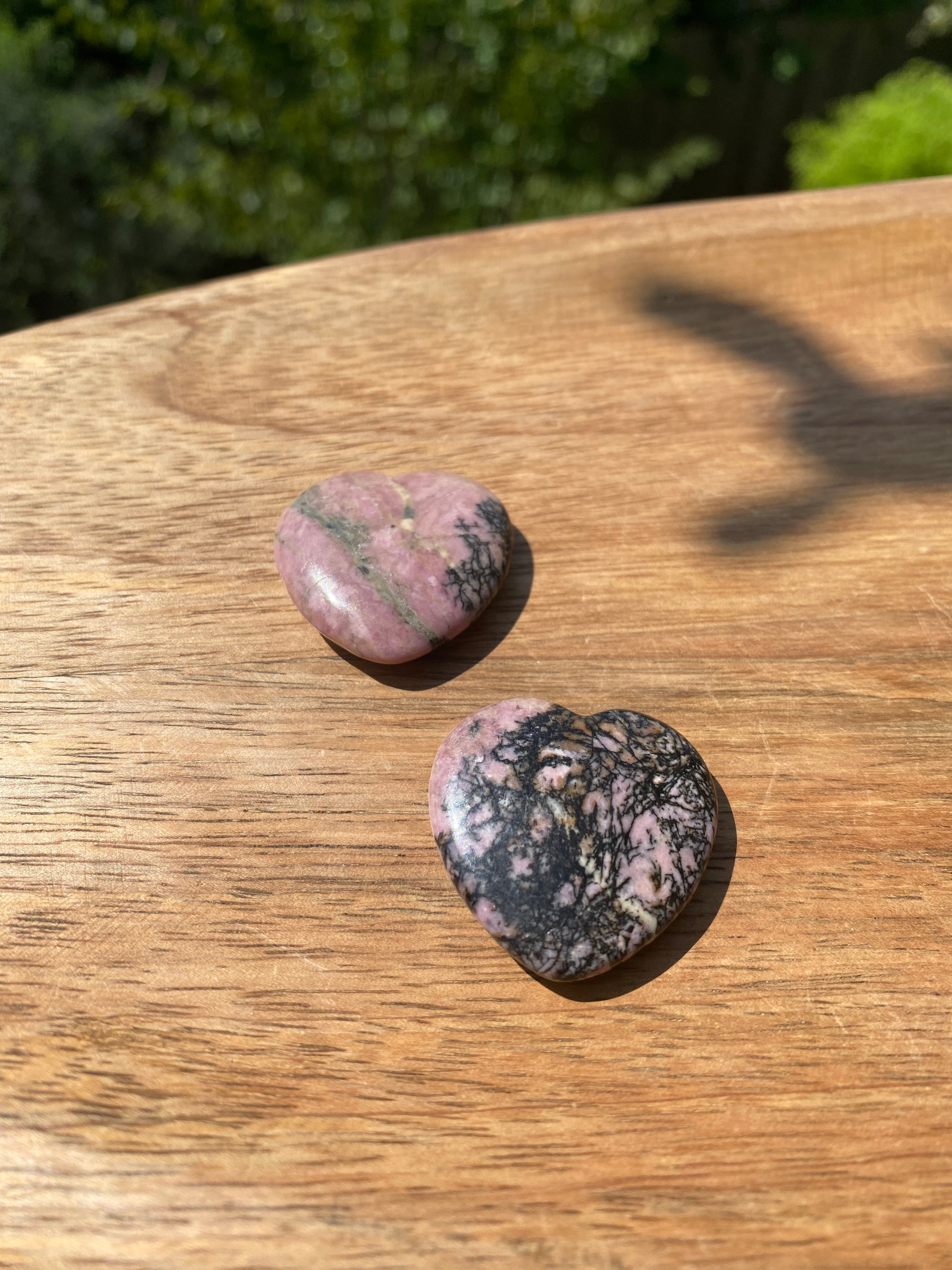 Rhodonite heart stone, aids in emotional balance, clears past wounds, and helps achieve your highest potential with compassion