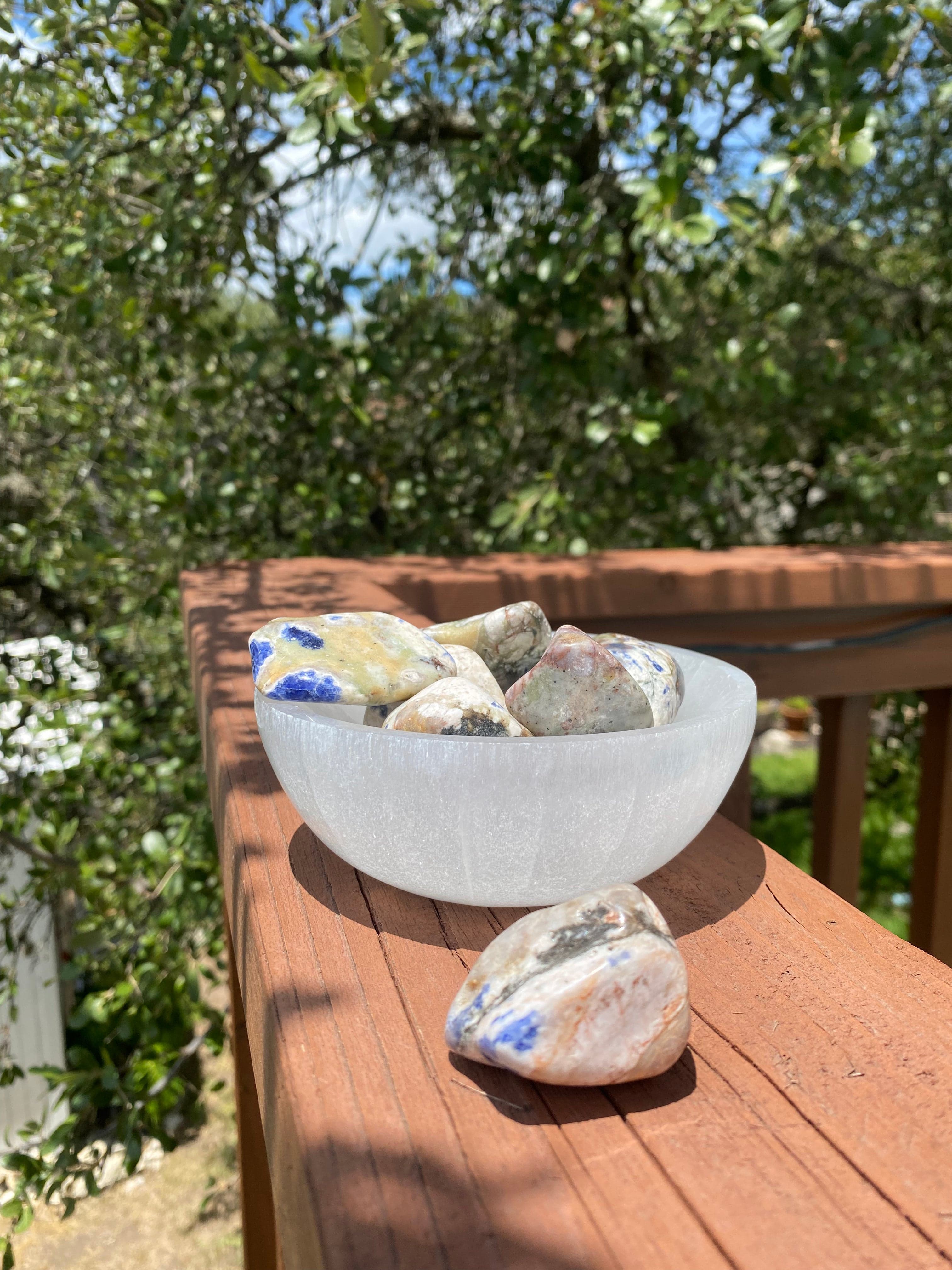 Sodalite Tumble, a calming stone, aligns with the throat and third eye chakra, encouraging rational thought, intuition, and emotional balance