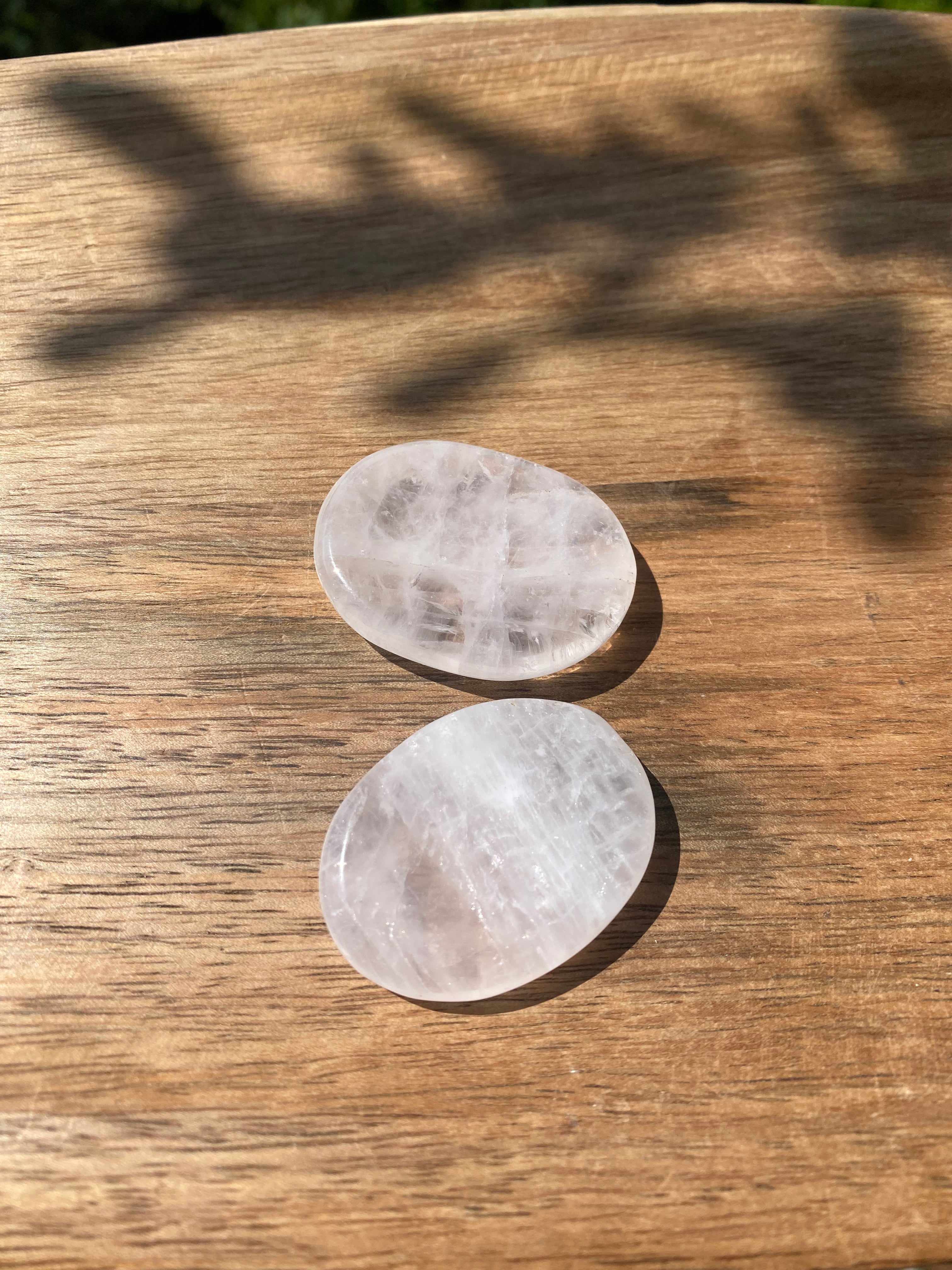 Gently hold and rub the Clear Quartz Worry Stone, known as the 'Master Healer,' to absorb stress and restore energetic balance