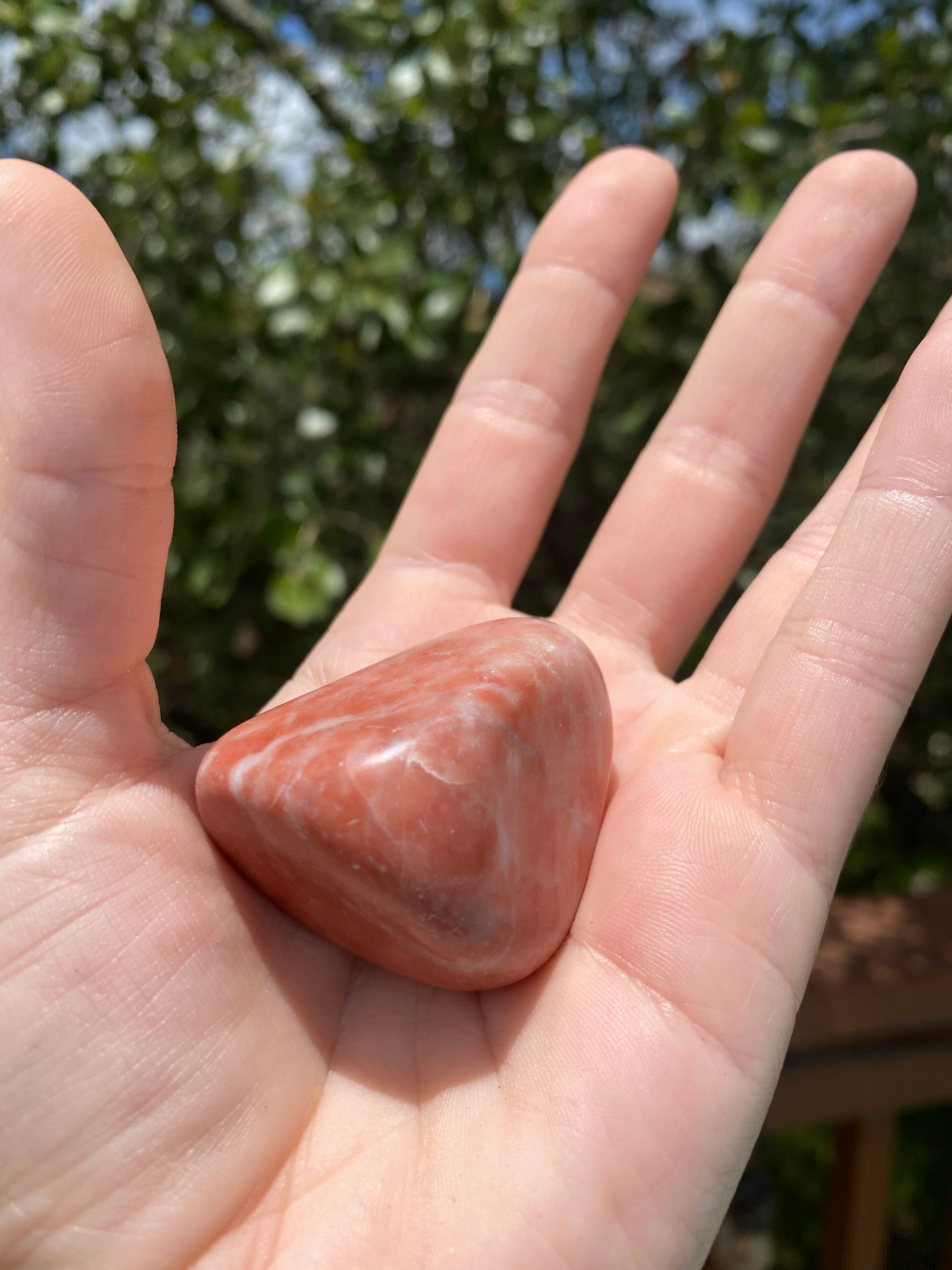 Red Aventurine Tumble glows under the sun, promoting vitality, balance, and physical action with its radiant red hues