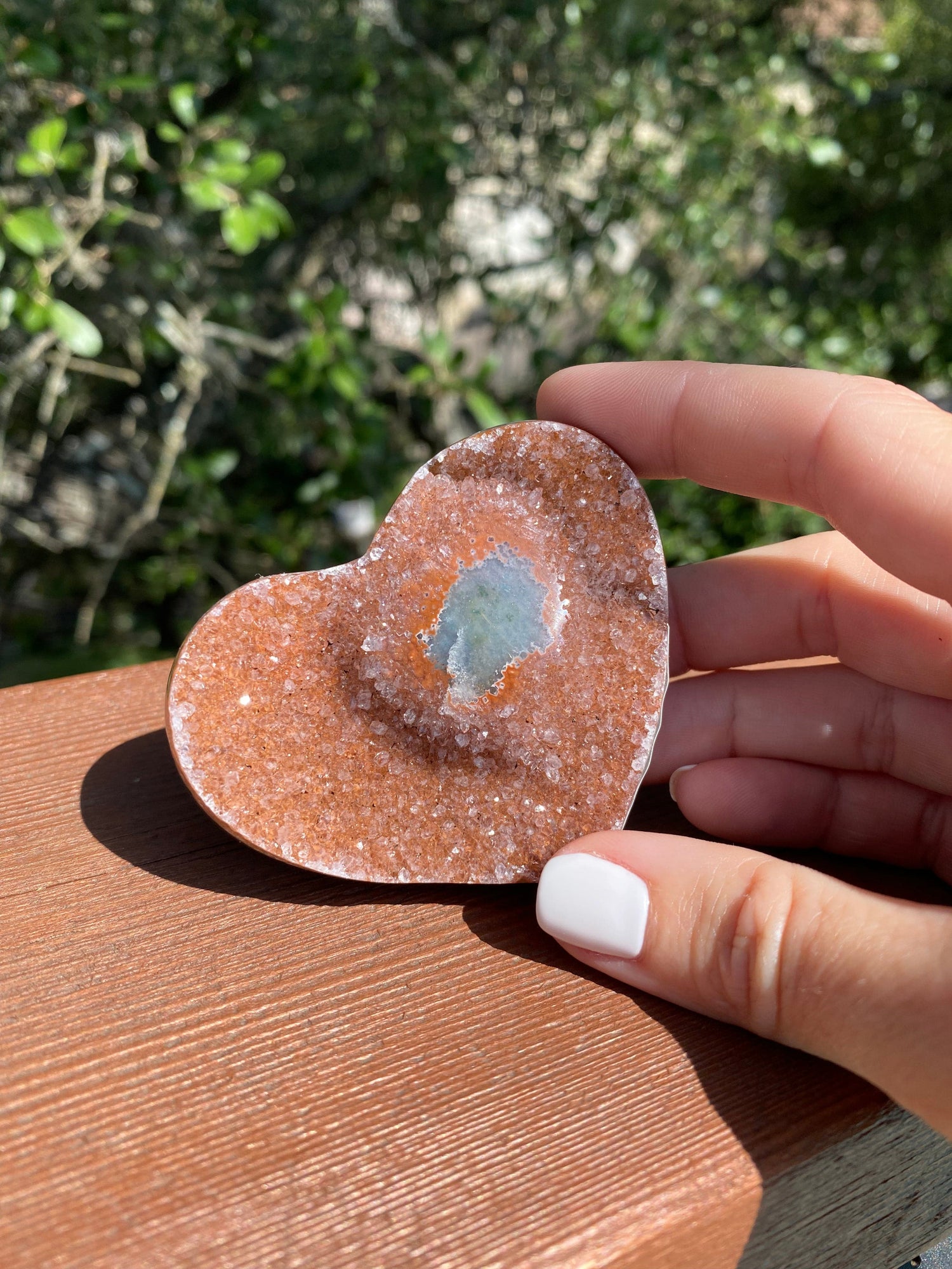 Under the sun, the Lavender and Rose Amethyst Heart glows, revealing its unique Agate core and enhancing its spiritual energy