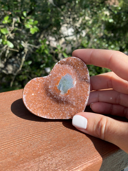 Under the sun, the Lavender and Rose Amethyst Heart glows, revealing its unique Agate core and enhancing its spiritual energy