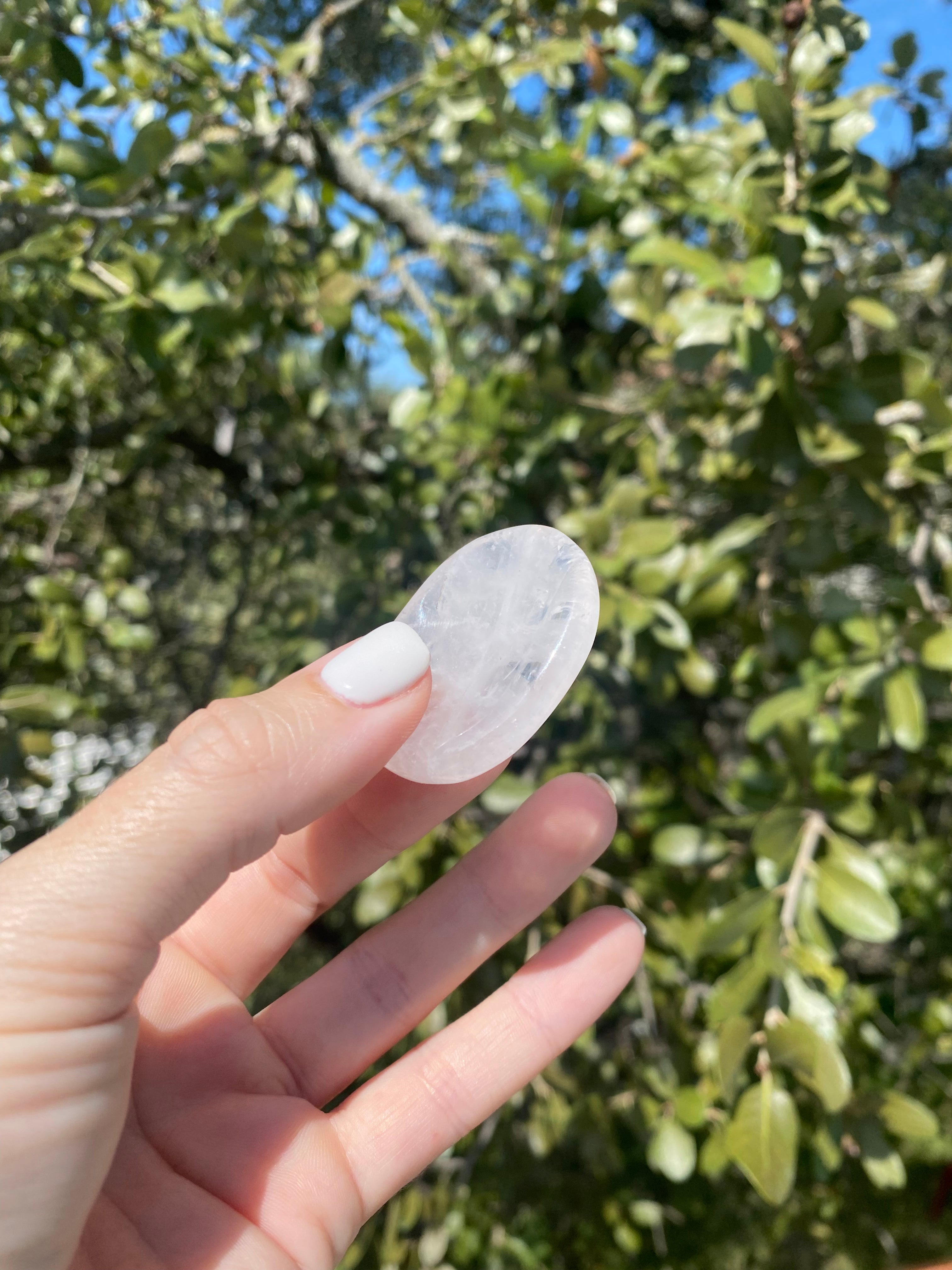 Gently hold and rub the Clear Quartz Worry Stone, known as the 'Master Healer,' to absorb stress and restore energetic balance