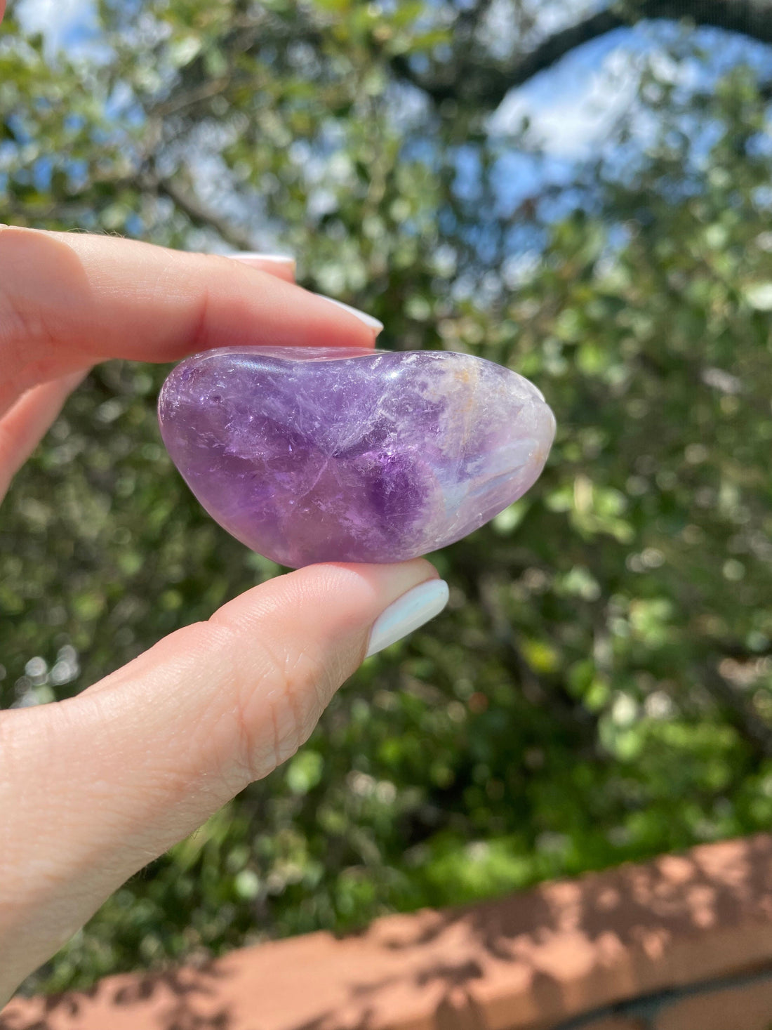 Amethyst tumble stone, known for relieving stress and anxiety, promoting balance and spiritual healing.