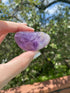 Amethyst tumble stone, known for relieving stress and anxiety, promoting balance and spiritual healing.